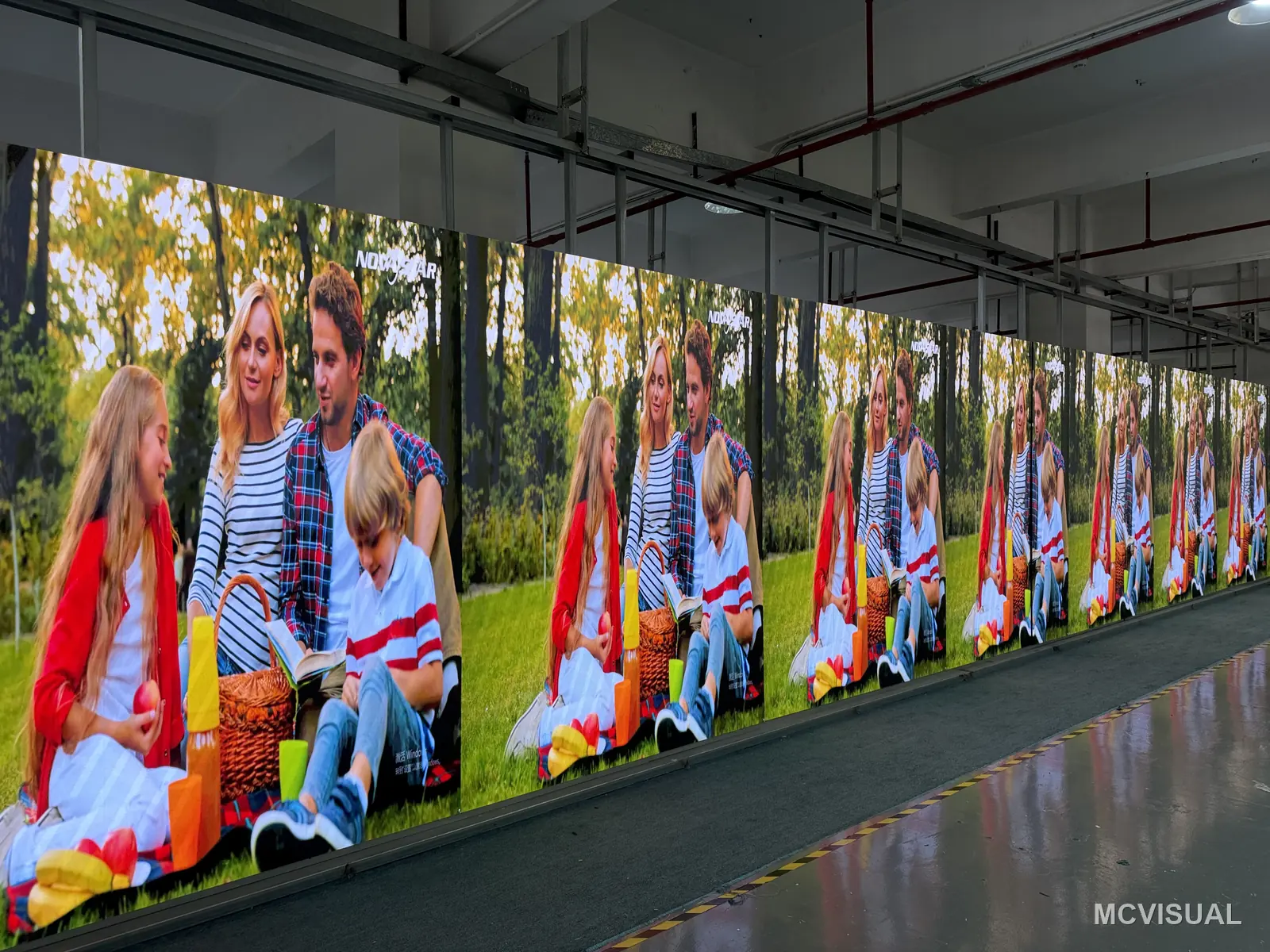 MCVISUAL factory aging bay, Shenzhen, China — Skin tones and greens compared along the whole row at once. Colour drift between cabinets is invisible on a single panel