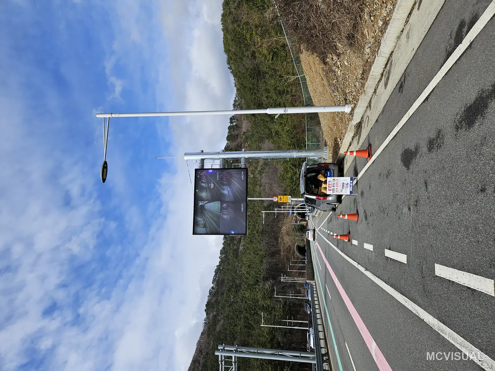 Tunnel approach traffic information display, Busan, South Korea — The roadside position ahead of the tunnel portal, where drivers go from daylight to darkness in seconds and the screen h