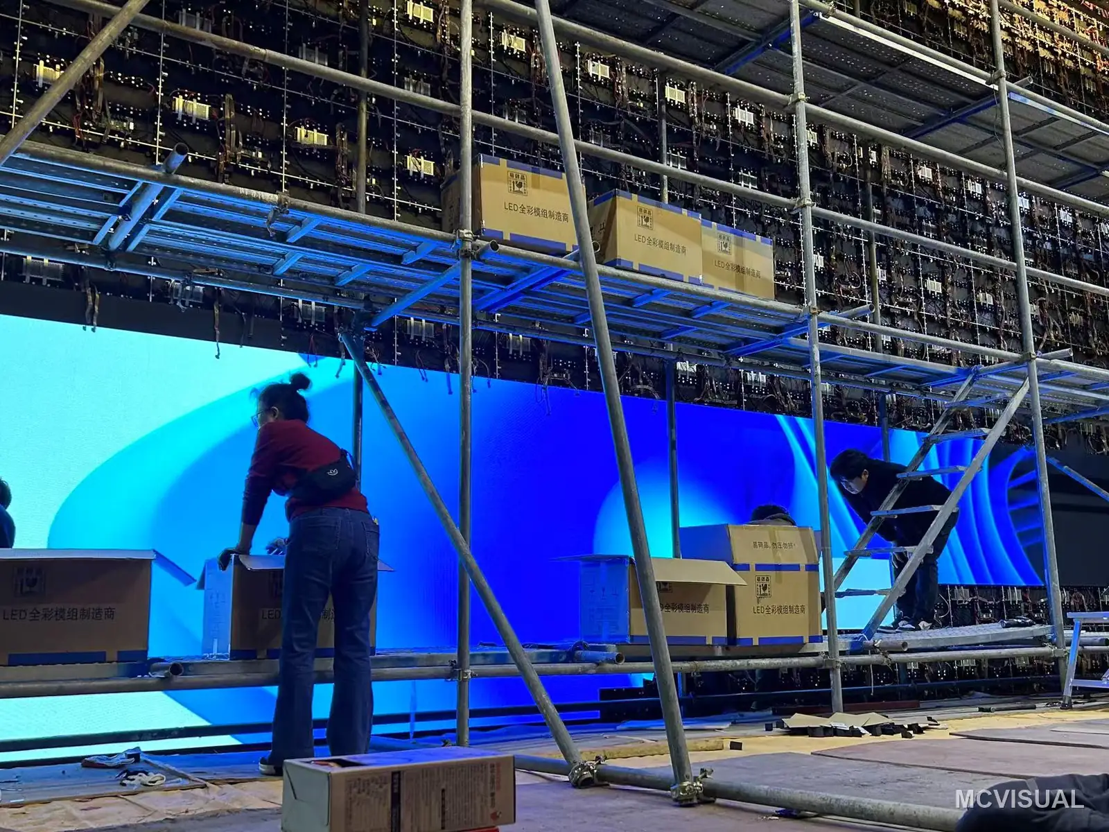 Daejeon banquet and convention hall, Daejeon, South Korea — Cabinets going up from scaffolding. 1114 die-cast 640 × 480 mm cabinets across two halls, hung row by row and mapped as