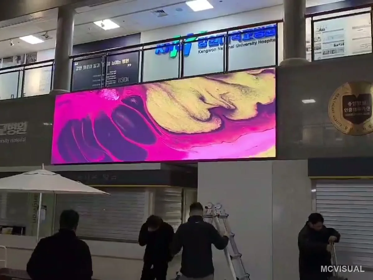 Kangwon National University Hospital, Chuncheon, South Korea — Artwork on the same screen. A hospital concourse runs wayfinding and notices most of the day, but visual content that lo