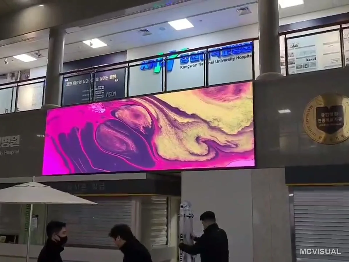 Kangwon National University Hospital, Chuncheon, South Korea — Commissioning, with the hospital's existing signage alongside. The screen was specified to sit with that signage ra
