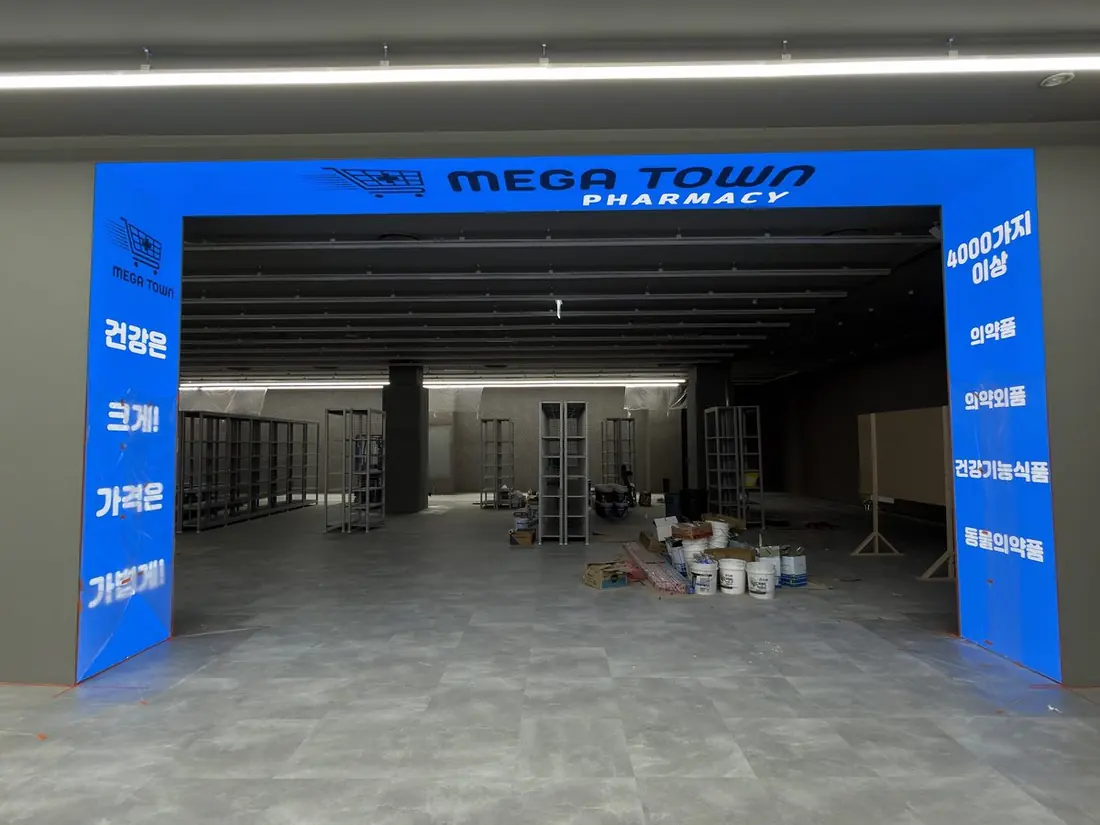 MEGA TOWN Pharmacy, South Korea — U-shaped entrance header and seven portrait pillar screens