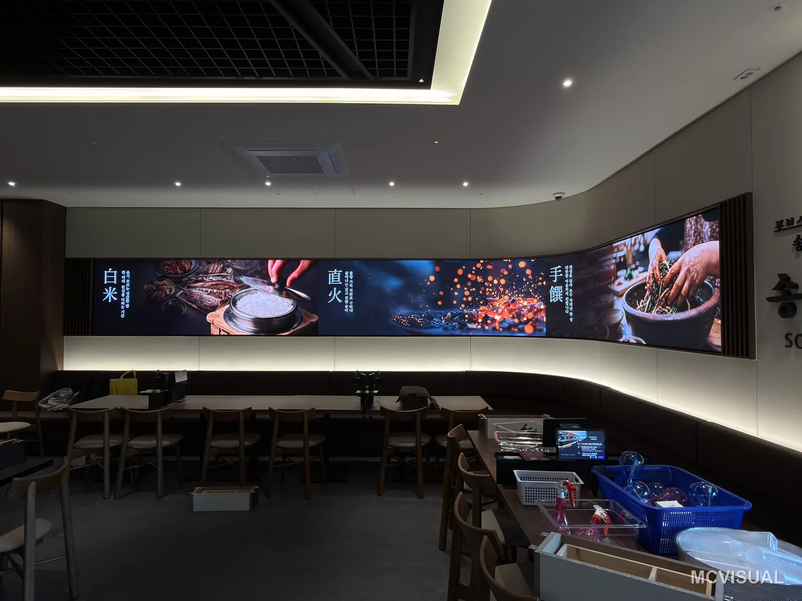 Restaurant dining hall, South Korea — The 8640 × 960 mm flexible run following the curved wall. Rigid cabinets would have stepped this curve and put a visible