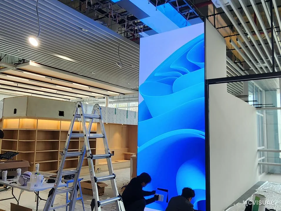 Retail concourse, South Korea — A screen wrapping a structural column. Columns are usually treated as obstacles; here the same 500 × 1000 mm cabinet for
