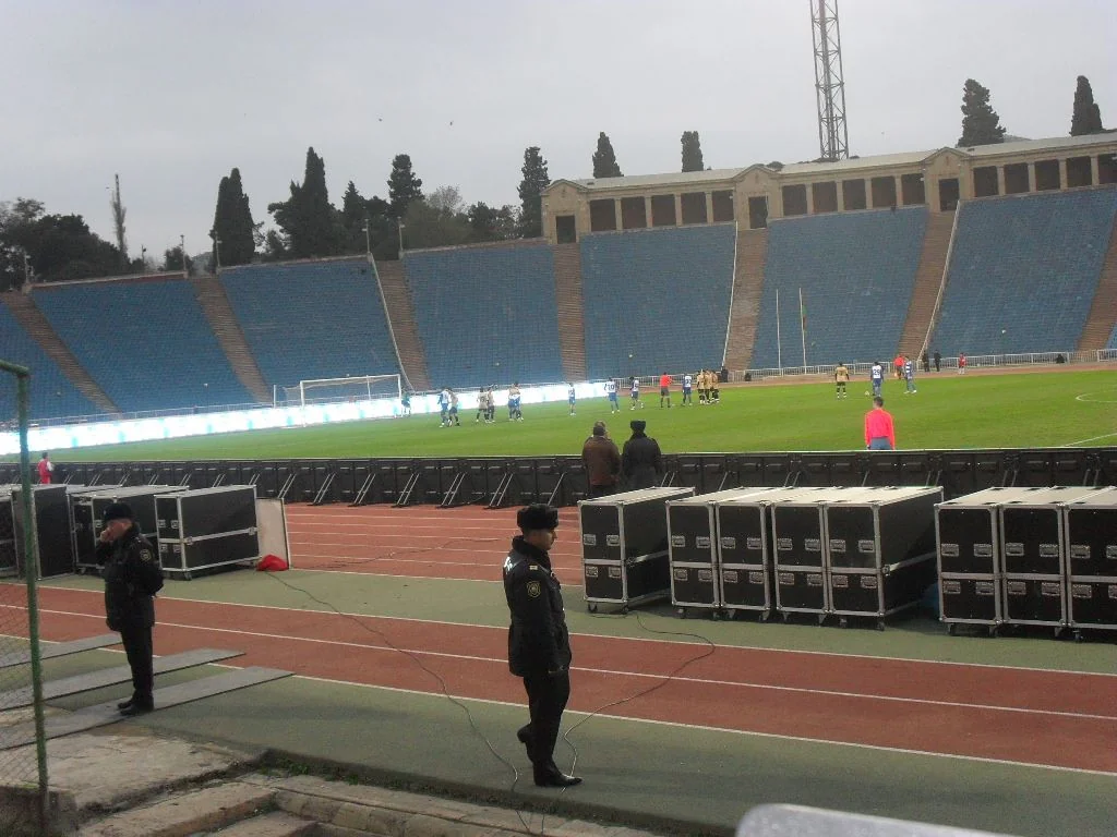 Pitch-side perimeter LED screens running in flat outdoor daylight at a stadium