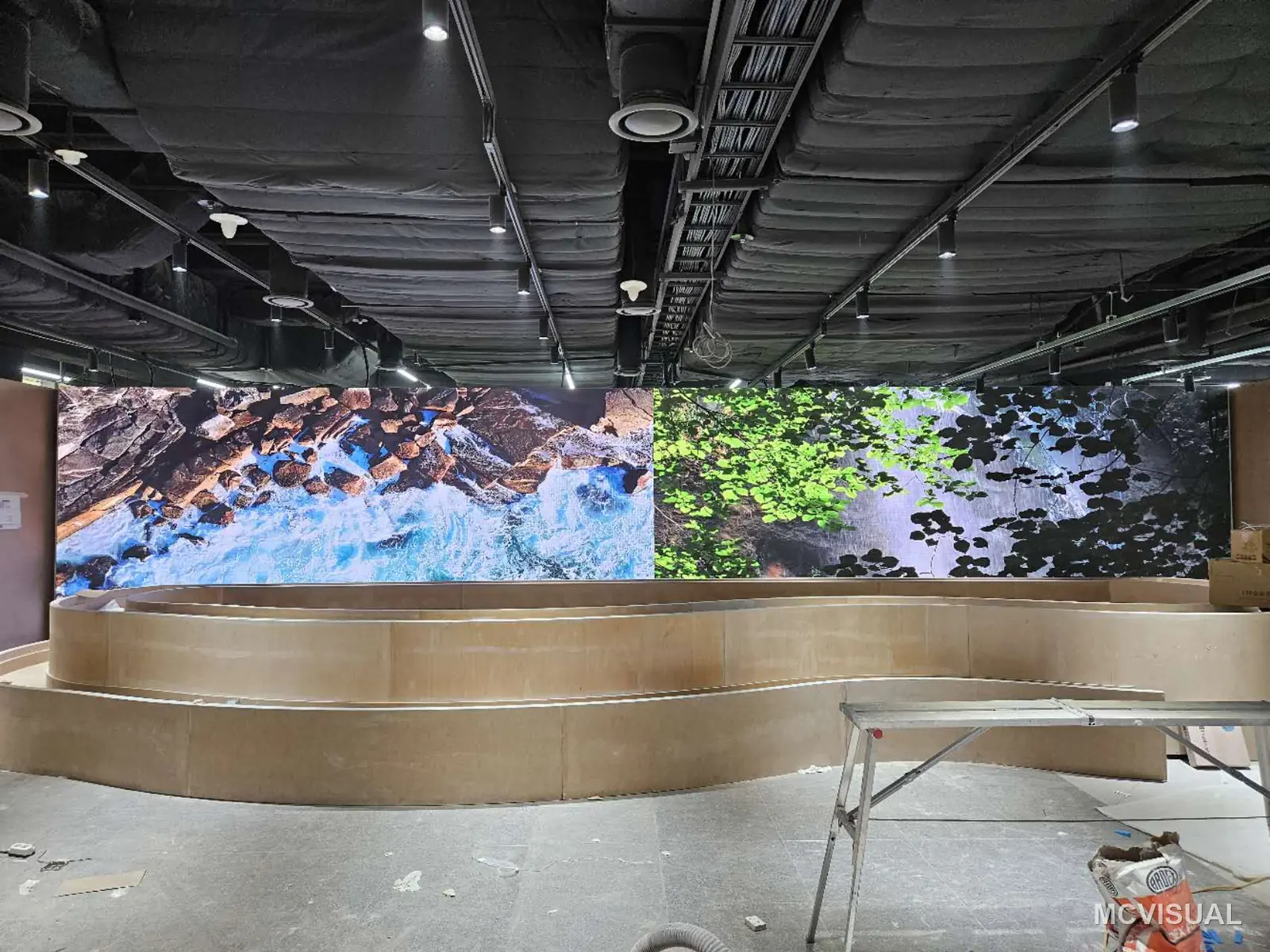 Wiggle Wiggle store, South Korea — The wall running coastal content during fit-out, before the joinery around it is finished. Retail projects work to a fix