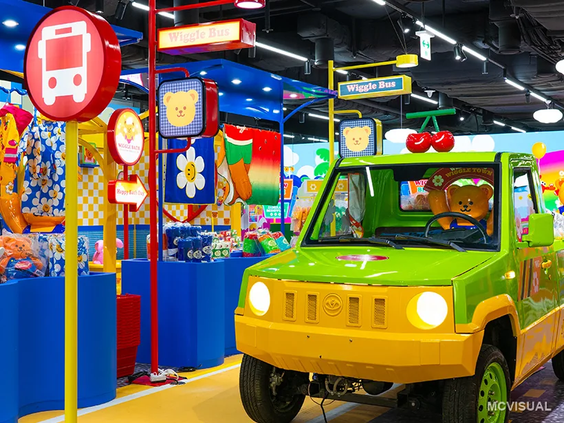 Wiggle Wiggle store, South Korea — A different section of the same installation, running its own artwork behind the ride area. The wall earns its cost by c