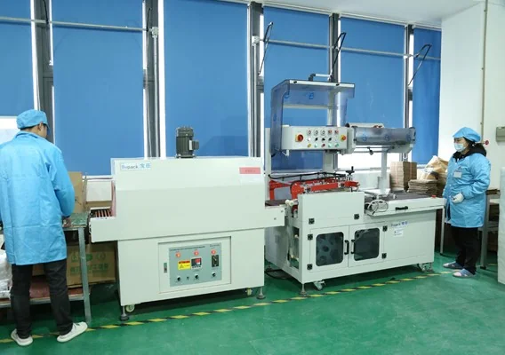 Shrink-wrap and packing station preparing cabinets for export